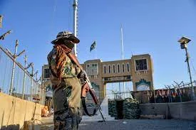 Afghan security stands guard at a fenced corridor of the Afghanistan-Pakistan border in Spin Boldak, Afghanistan [AFP]