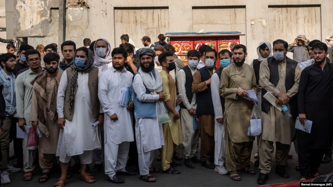 Afghans line up outside the Iranian Embassy in Kabul to request travel visas on September 29. [AP]